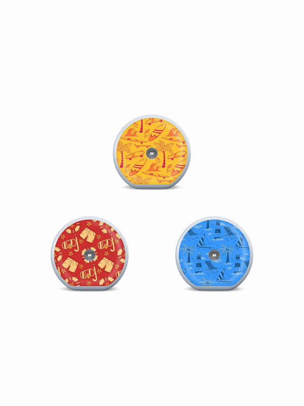 Three Accu-Chek SmartGuide sensor stickers with surfboards, snorkels and seaside illustrations in warm summer colors.