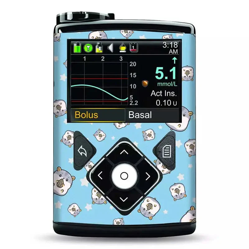 Medtronic Minimed insulin pump adorned with a blue vinyl sticker featuring cute, small animal faces and stars. The device screen displays glucose monitoring data. Obraz