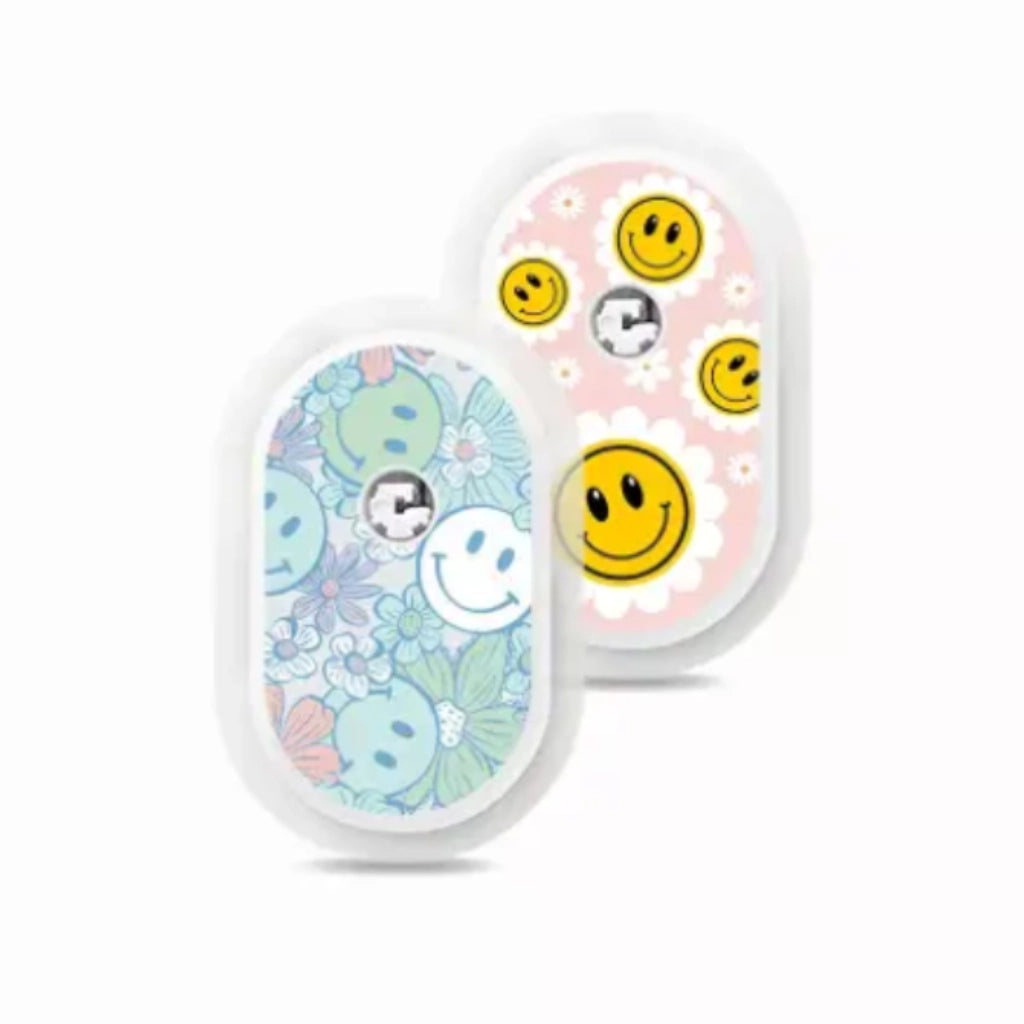 Sibionics GS1 CGM devices with colorful vinyl stickers, featuring smiley faces and floral designs. Obraz