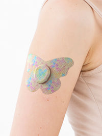 Plaster mocujący do Dexcom G7, kształt: motyl, na ramieniu, zbliżenie