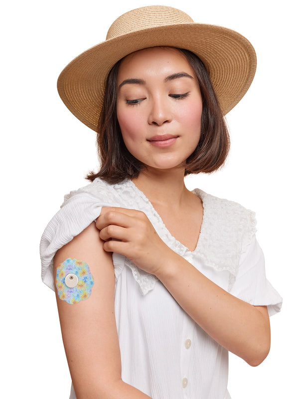 FreeStyle Libre 3 cookie shape patch worn on a woman’s arm, with breathable adhesive fabric for sensor support