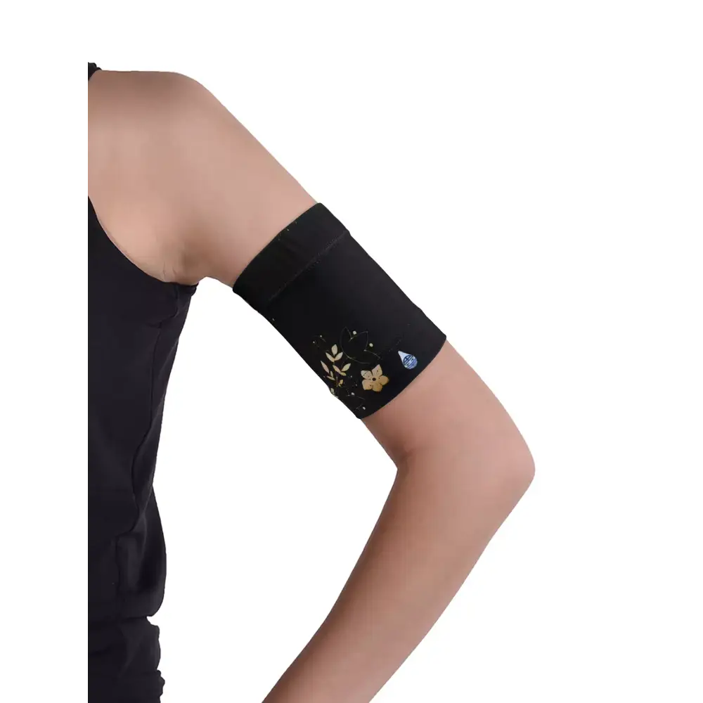 Glucose monitor and insulin pump armband in black with floral design worn on upper arm for secure diabetes device management