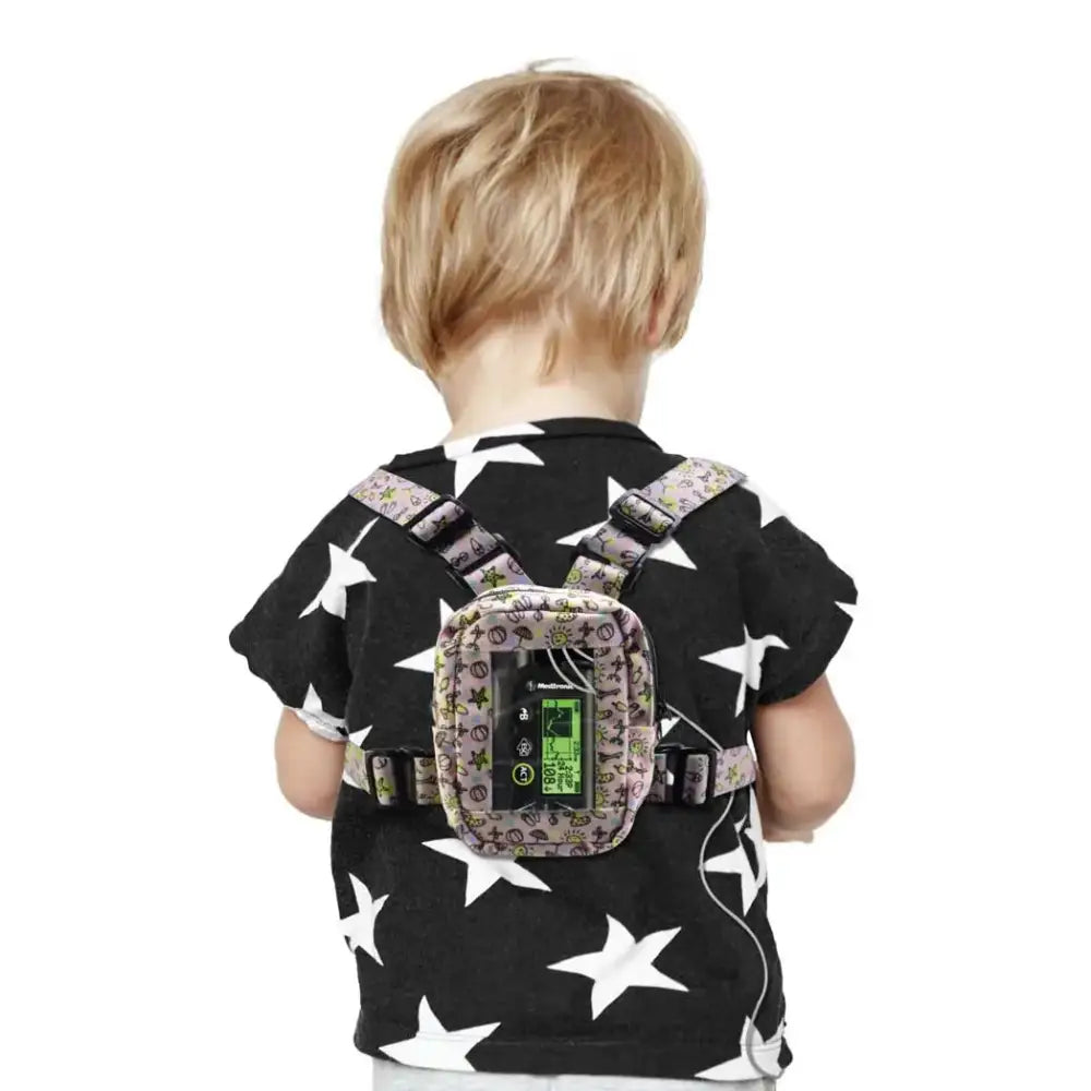 Child wearing Dia-Harness insulin pump with window, adjustable straps, and secure back pocket.