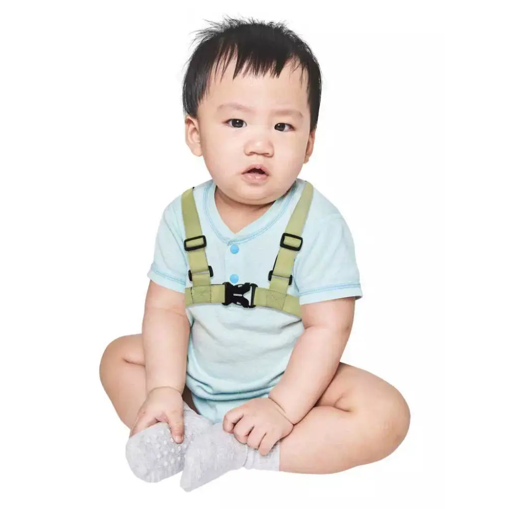 Insulin pump harness for kids in green, worn by a toddler.